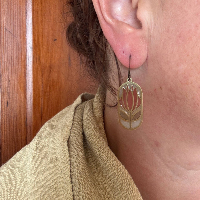 Cloisonné Stained Glass Resin Earrings by Wild Lupine Folkcraft, worn on an ear, highlighting the elegant brass design and soft-colored resin detail.