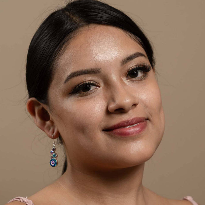 Model wearing geometric crystal round earrings by Mosaico Jewels, presenting a modern look with colorful accents.