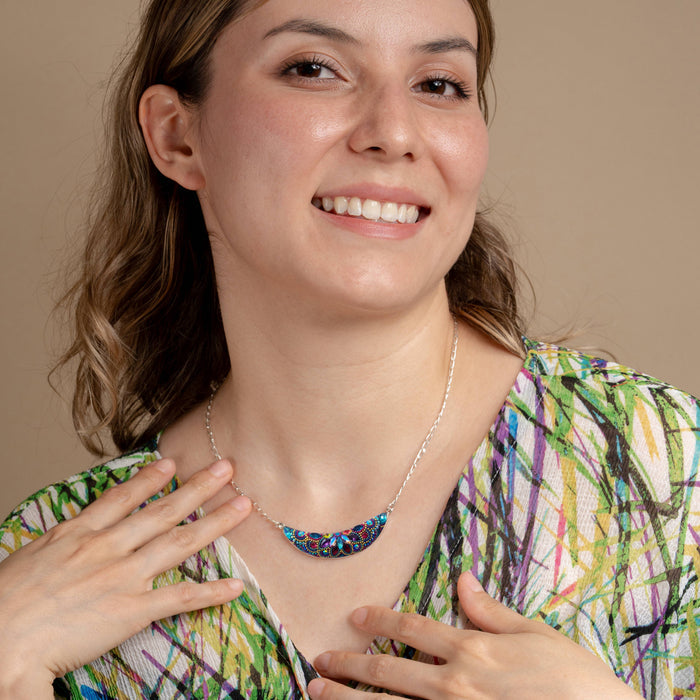 Model wearing the Luna Crystal Necklace by Mosaico Jewels, displaying the crescent moon design with colorful beadwork, set against a neutral backdrop.