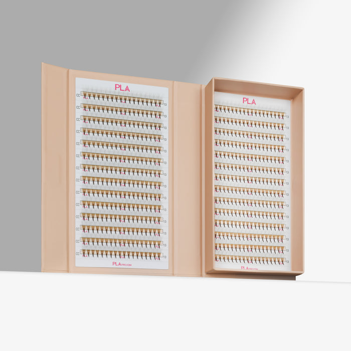 Open box containing multiple rows of eyelash extension promades on a gray background