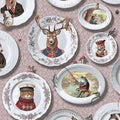 Tales of the Manor blush wallpaper with china plates holding animal portraits including a stag in uniform and a frog fishing